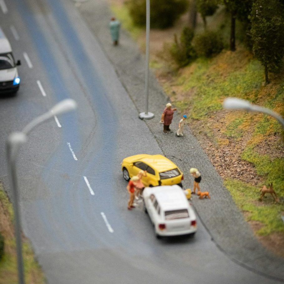 Beispielfoto mit zwei Spielzeugautos auf einer Straße, mit Figuren, die einen Unfall hatten.