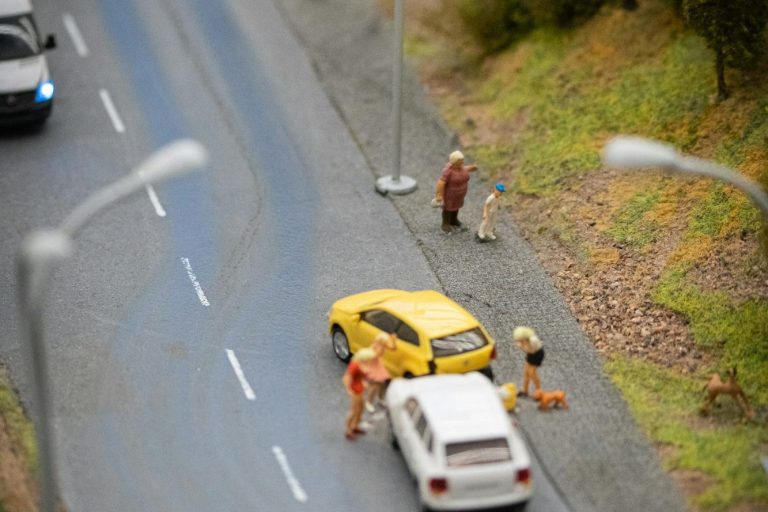 Beispielfoto mit zwei Spielzeugautos auf einer Straße, mit Figuren, die einen Unfall hatten.